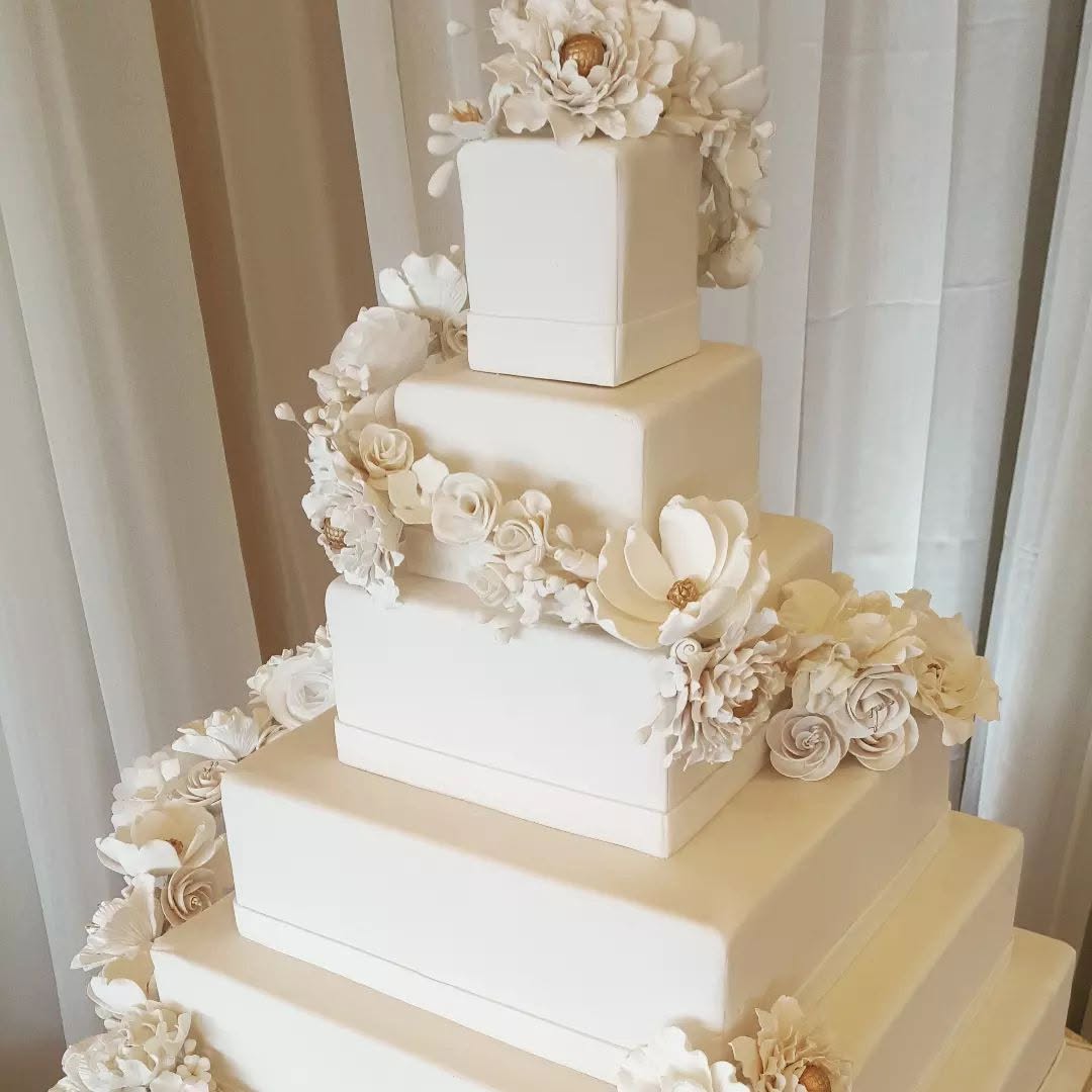 Ivory square-tiered wedding cake with sugar peonies