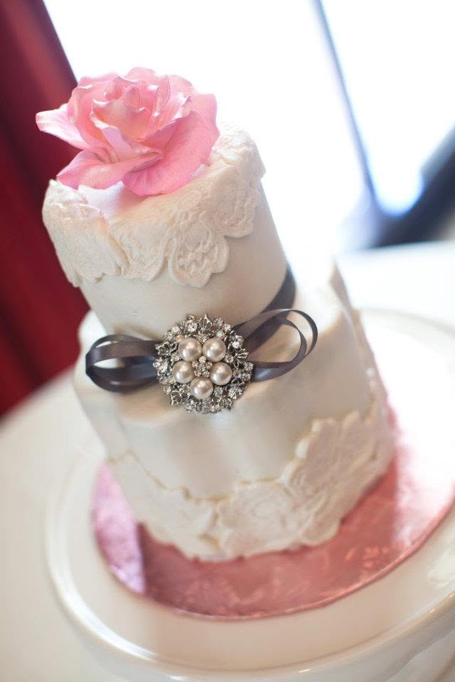 White lace cake with pink rose and brooch